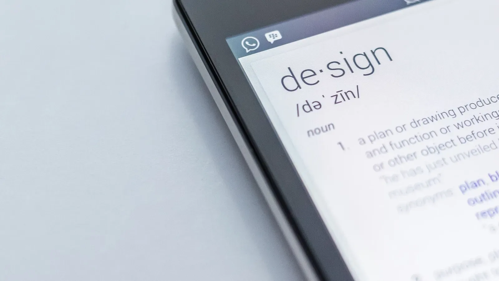Layar smartphone menampilkan definisi kata design dari kamus